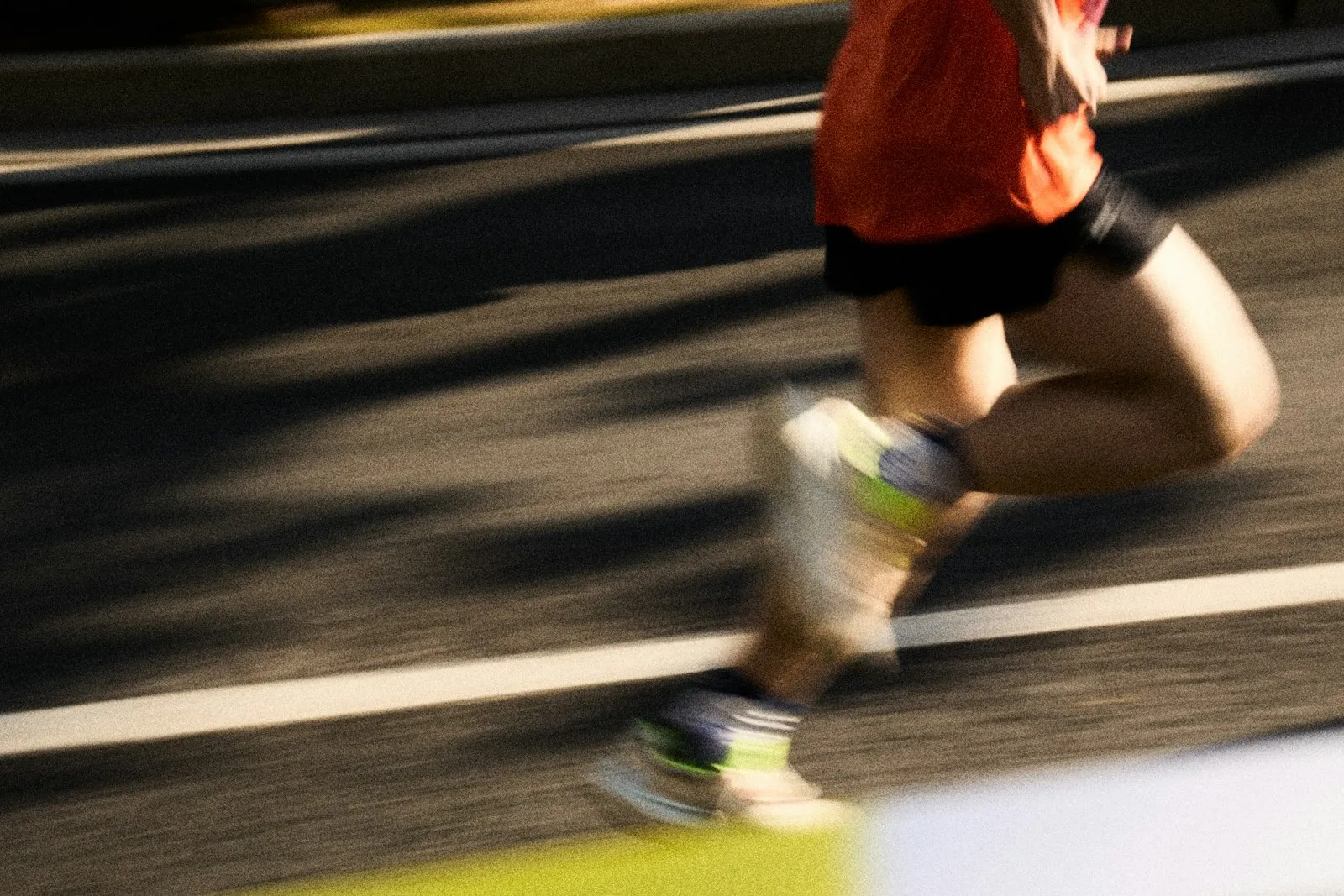 A runner in motion on a city street, caught mid-stride