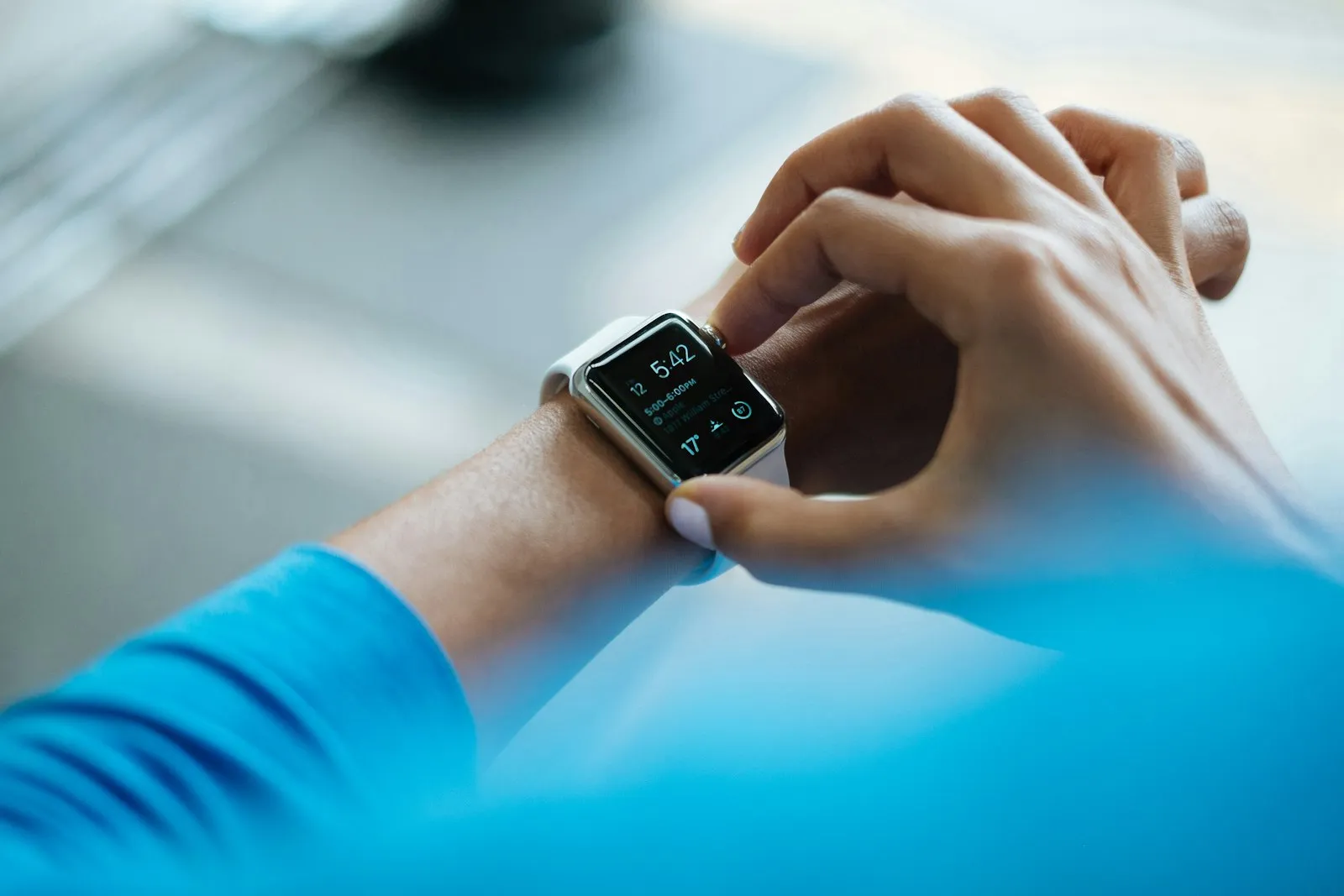 A person tapping the screen of a smartwatch on their wrist