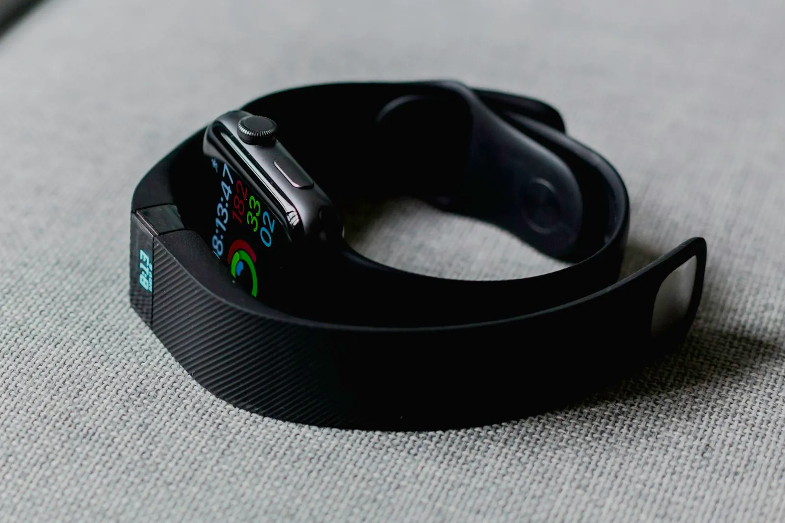 A fitness tracker band resting on a desk, screen dark